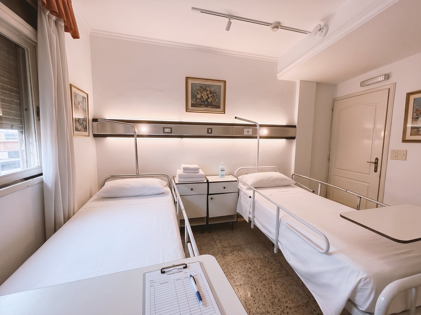 Habitación doble con camas articuladas y panel de cabecera